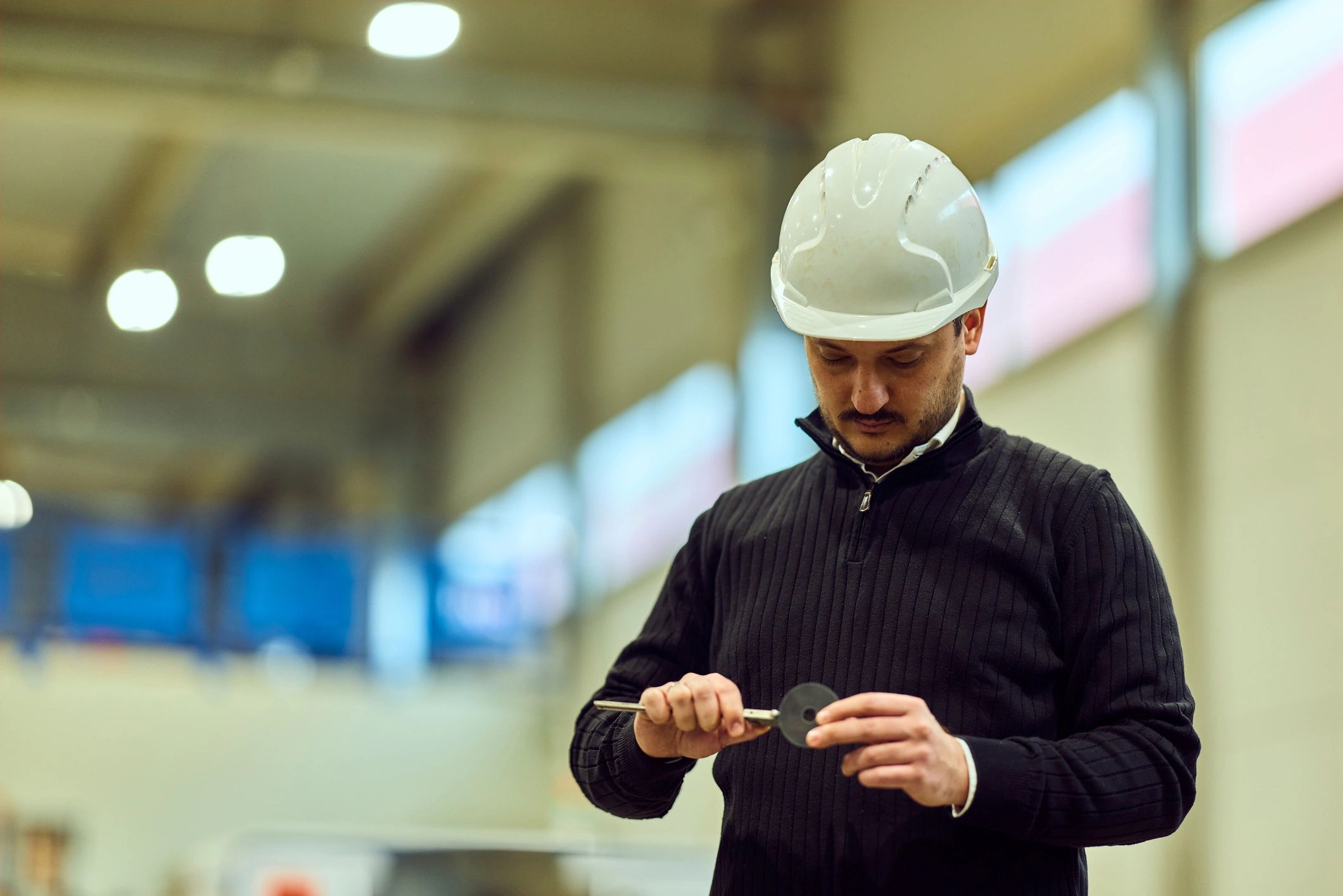 Technician in a factory setting wearing a safety helmet