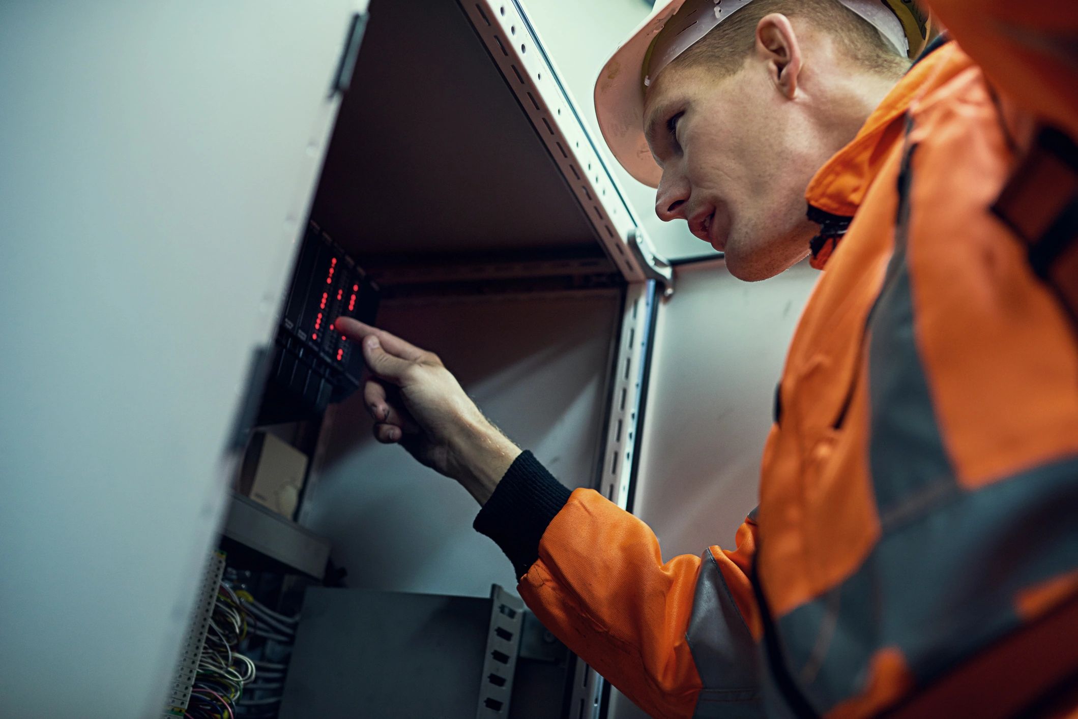 Elevator technician working on machinery while wearing safety gear